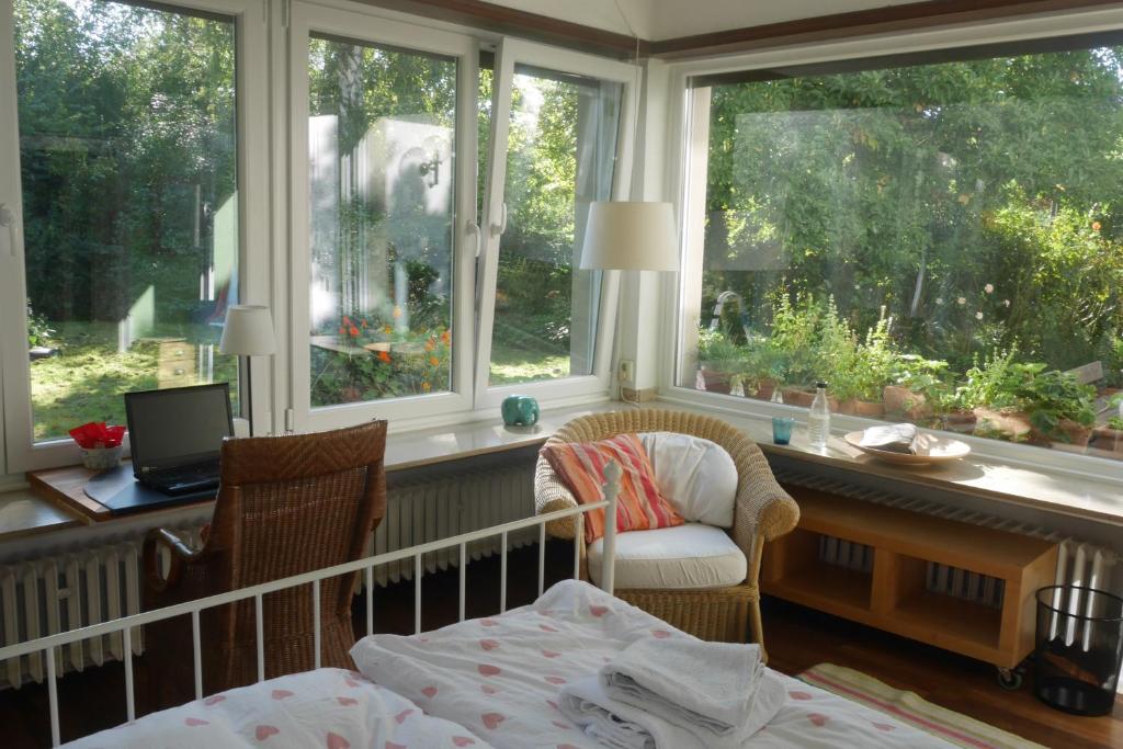 Schlafzimmer mit einem Bett, einem Schreibtisch und Fenstern in der Unterkunft Glück in Benrath in Düsseldorf