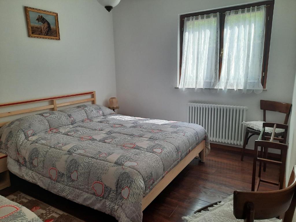 una camera con un letto e una sedia e una finestra di Appartamento HAPPY DAYS (CIPAT: 022139-AT-837180) a Pergine Valsugana