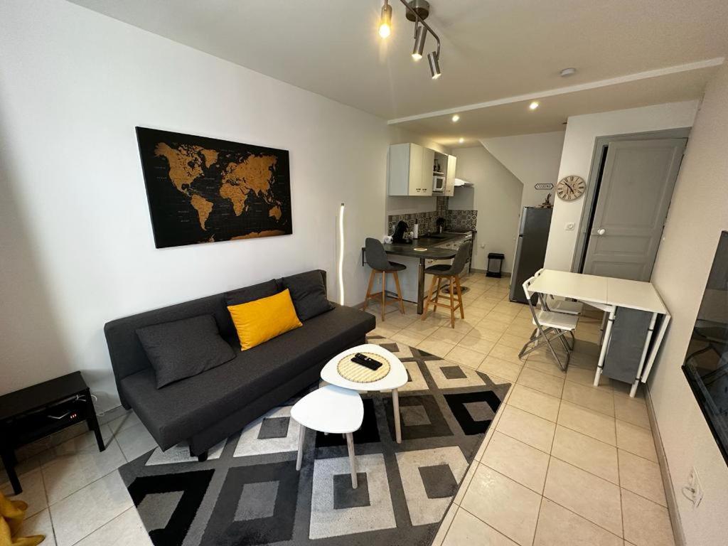 sala de estar con sofá y mesa en Le Saint Maixent, Maison de Ville, Baby Foot, wifi, en Saint-Maixent-lʼÉcole