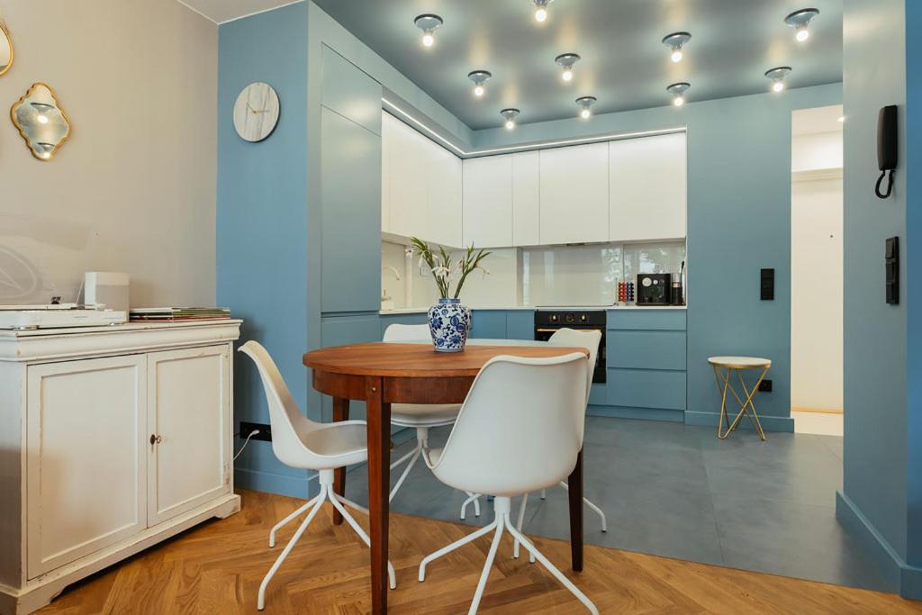 a blue and white kitchen with a table and chairs at Project Comfort Apartament Aleje Jerozolimskie 131/12 Warszawa in Warsaw