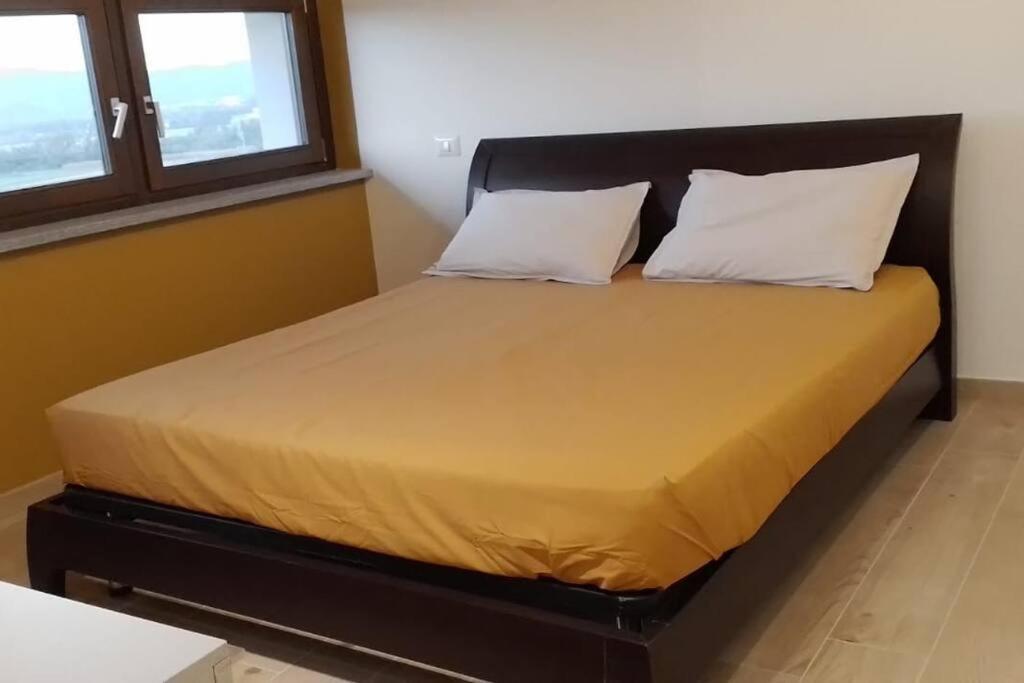 Bett in einem Zimmer mit zwei Kissen darauf in der Unterkunft Appartamento dei Tigli in Bra