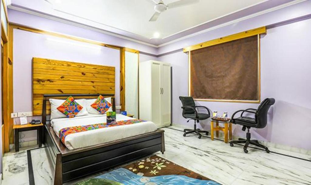 a bedroom with a bed and two chairs in it at FabHotel The Lodge in Jaipur