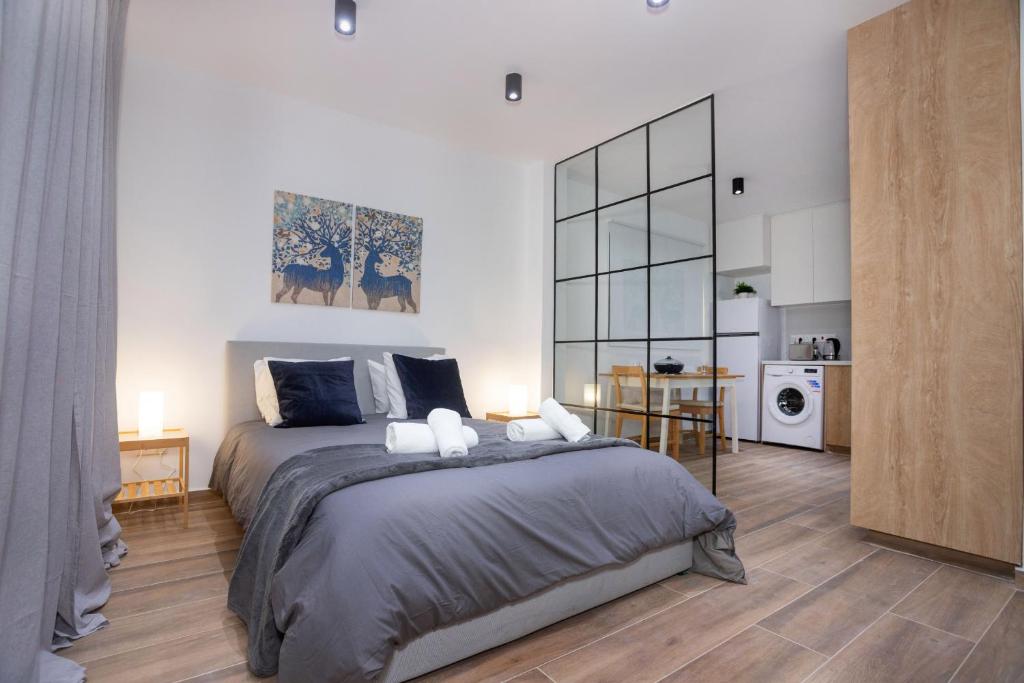 a bedroom with a large bed and a kitchen at STAY Zen Studio in Limassol