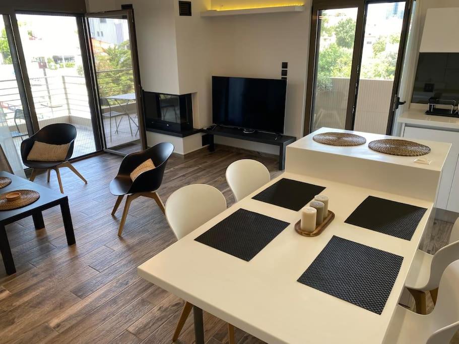 ein Wohnzimmer mit einem weißen Tisch und Stühlen in der Unterkunft Dazzling and stylish 2BR Apartment in Athen