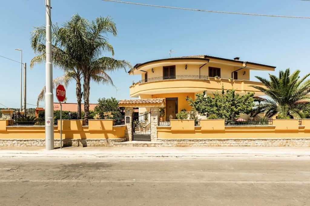 un edificio giallo con un cartello di stop davanti di Casa Relax Salento - Relax House in the village a Specchia