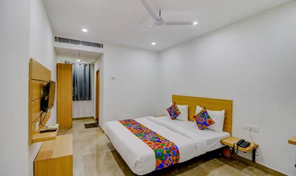 una camera con un letto e una televisione di FabHotel Premium Kashi a Varanasi