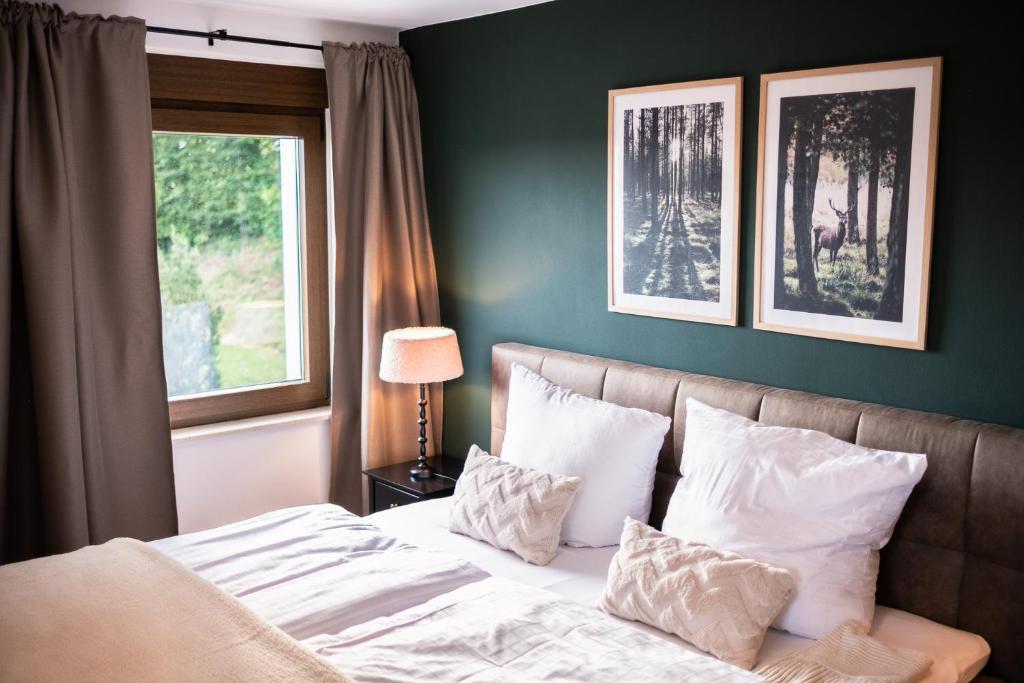 a bedroom with a bed with pillows and a window at Eifellodge - am roten Sandberg in Prüm