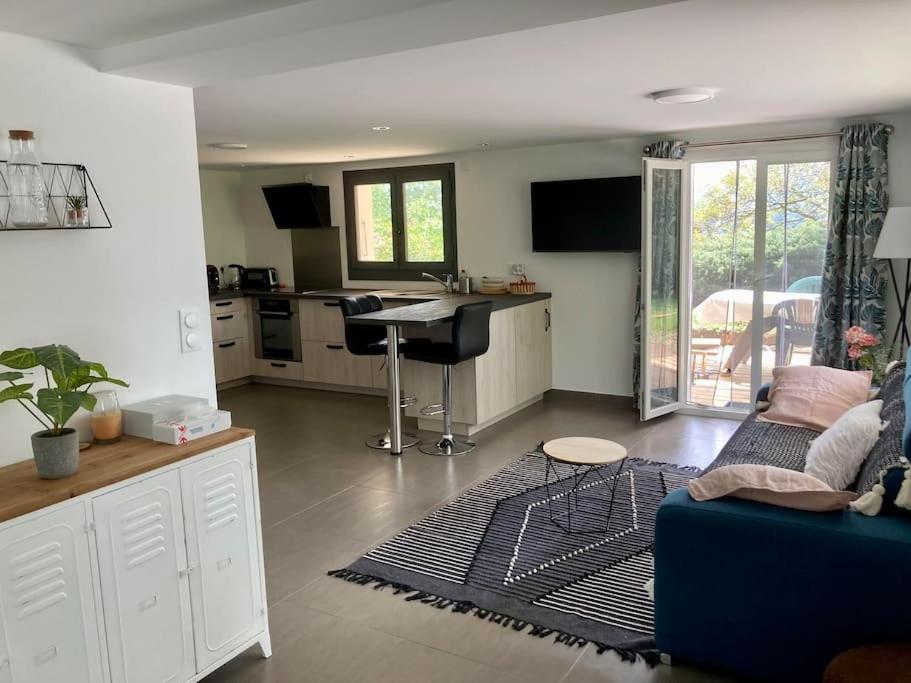 ein Wohnzimmer mit einem blauen Sofa und einer Küche in der Unterkunft Appartement cosy entre Genève et Annecy 