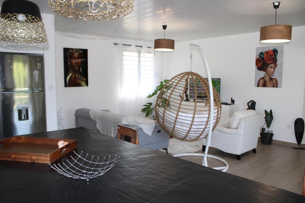 a kitchen and living room with a table and a large orb at Villa Perle -proche aéroport in Matoury