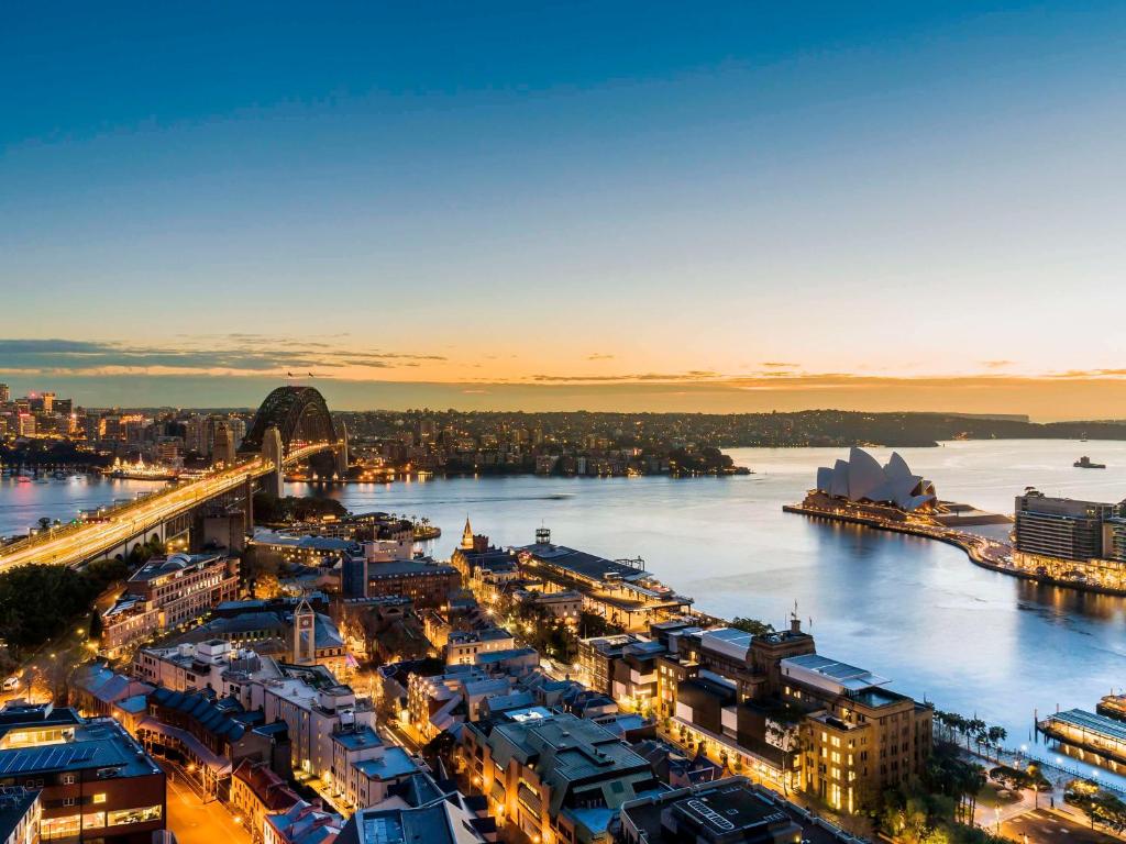 an aerial view of a city with a river and a bridge at The Sebel Quay West Suites Sydney in Sydney