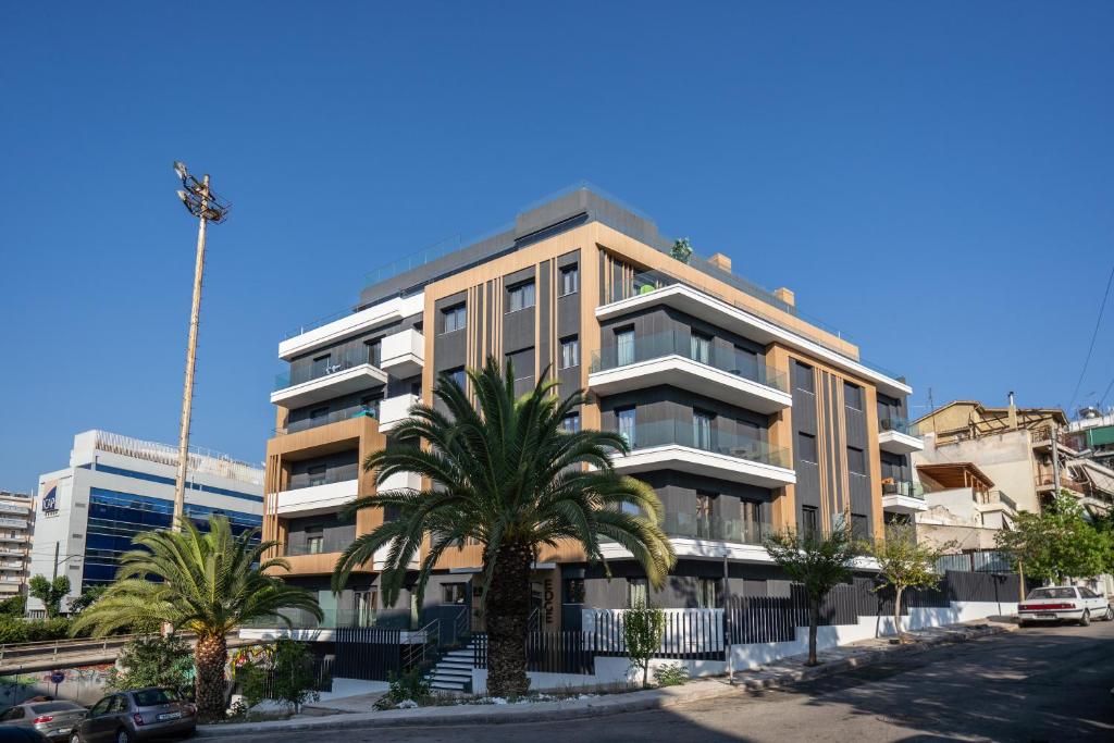 un grand bâtiment avec des palmiers devant lui dans l'établissement The Edge - Luxury Residences, à Athènes