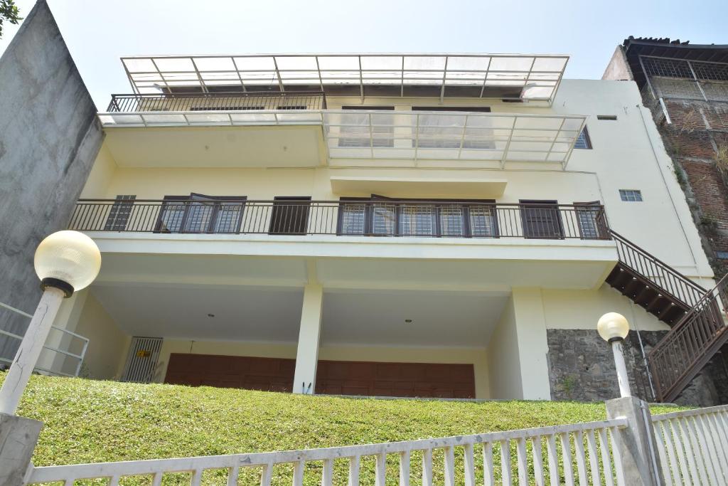 Casa blanca con balcón y escaleras en Kerinci Hill Holiday Home, Dago Golf (for families only), en Bandung
