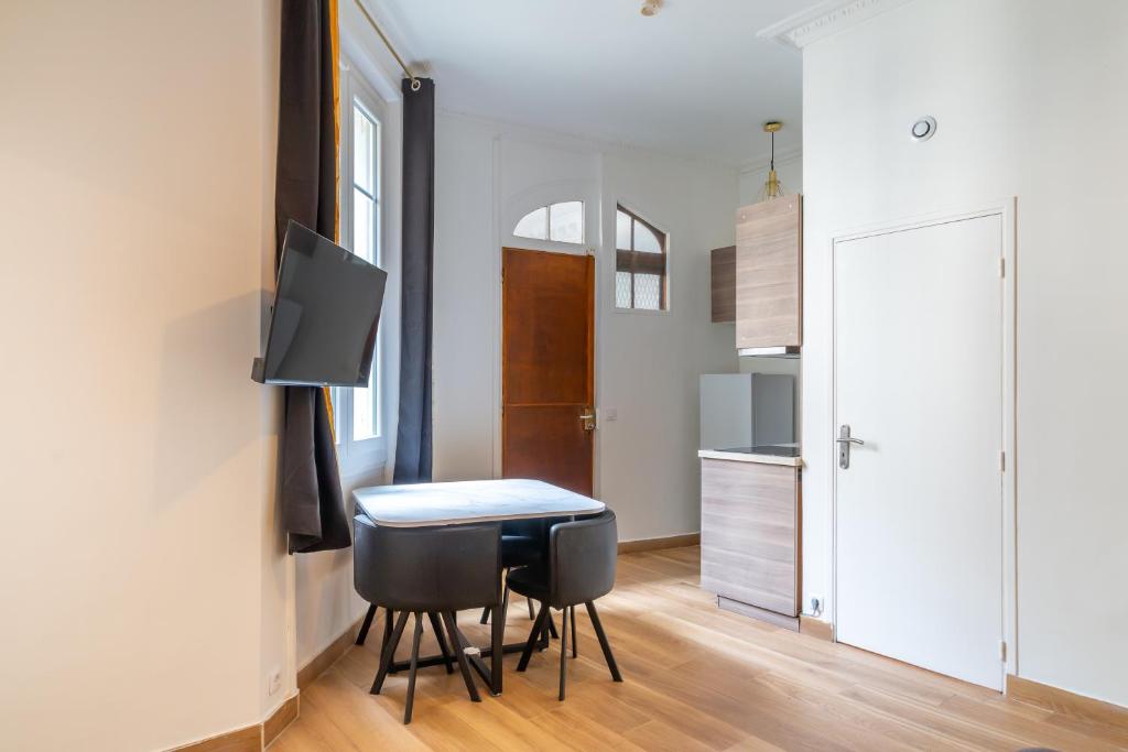 une petite cuisine et salle à manger avec une table et des chaises dans l'établissement Appartement Métro Alexandre Dumas, à Paris