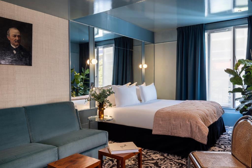 a hotel room with a bed and a couch at Hôtel La Conversation in Paris