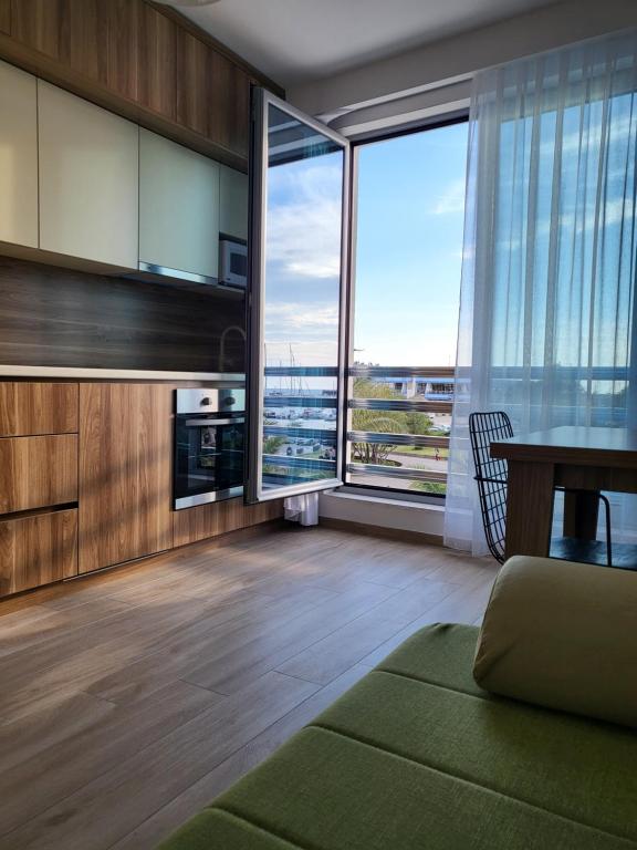 a living room with a table and large windows at Apartmani Port in Bar