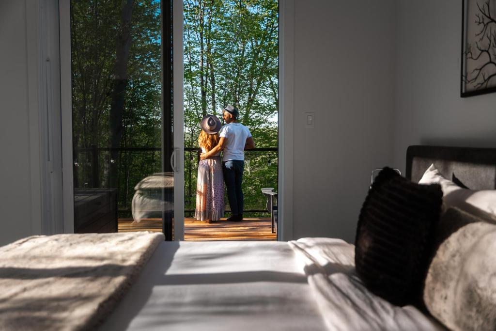 a man and a woman standing outside of a door at Bellaria with SPA near Mercier Lake in La Conception