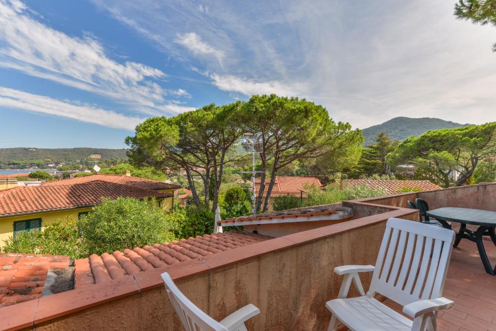 une terrasse avec 2 chaises et une table sur un mur dans l'établissement Casa Elba, à Procchio