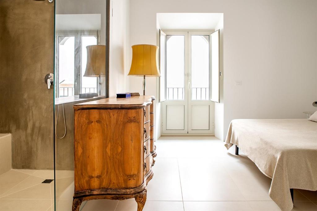 um quarto com uma cama e uma cómoda com um candeeiro em Mazzini 5 em Ragusa
