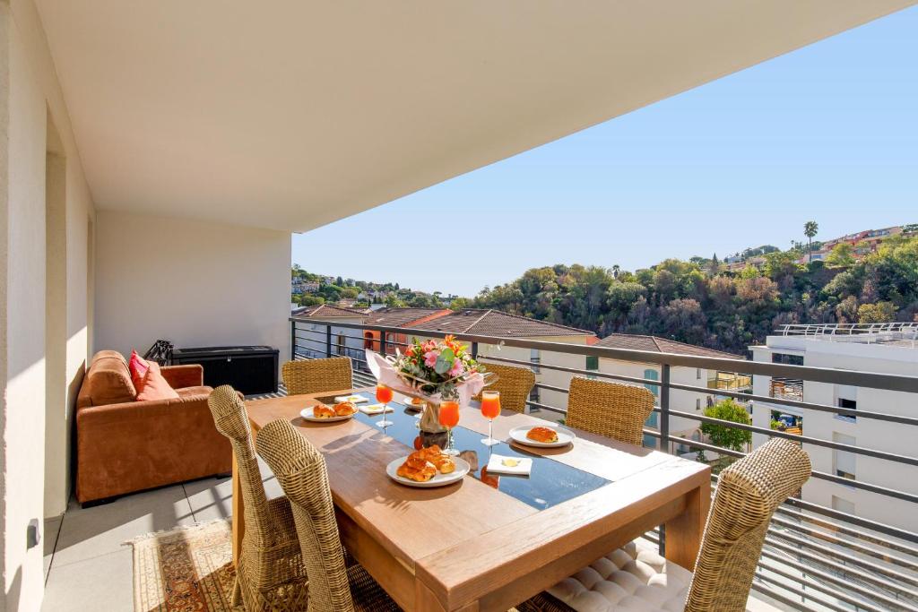 y balcón con mesa de comedor y sillas. en Lovely 2 bedroom condo with pool, en Vallauris
