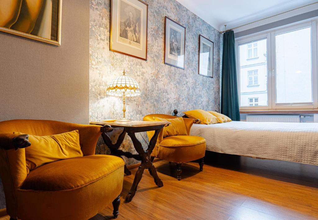 una camera da letto con un letto, due sedie e un tavolo di Art Apartament Chmielna 10 a Varsavia