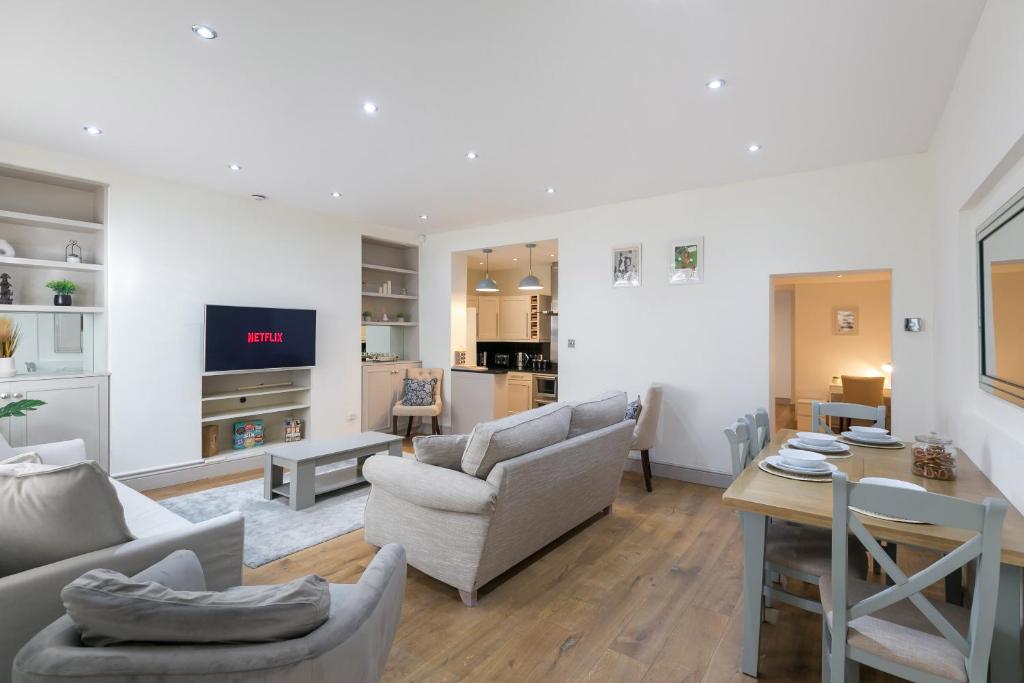ein Wohnzimmer mit Sofas und einem Tisch in der Unterkunft The Notting Hill Residence - 2 BR Apartment Close to Hyde Park in London