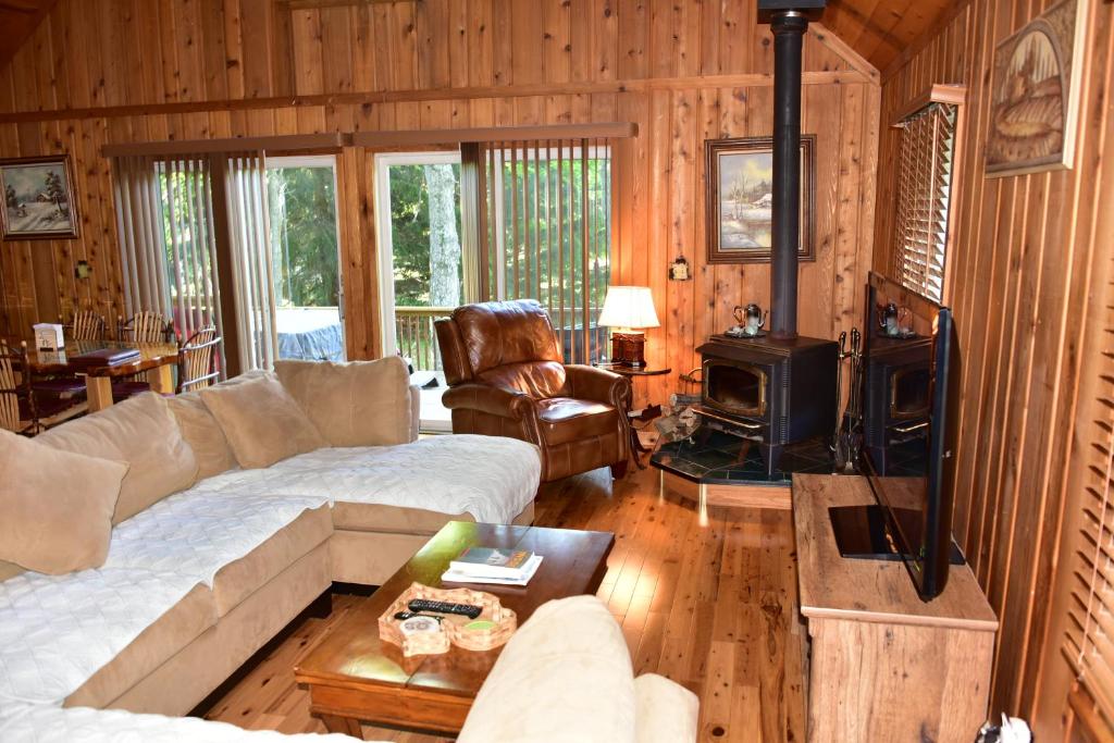 a living room with a couch and a stove at Quiet and Comfy 3bed/2bath - Chalet with hot tub. in Cedar