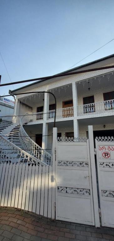 a house with a white gate and a building at шорена in Batumi