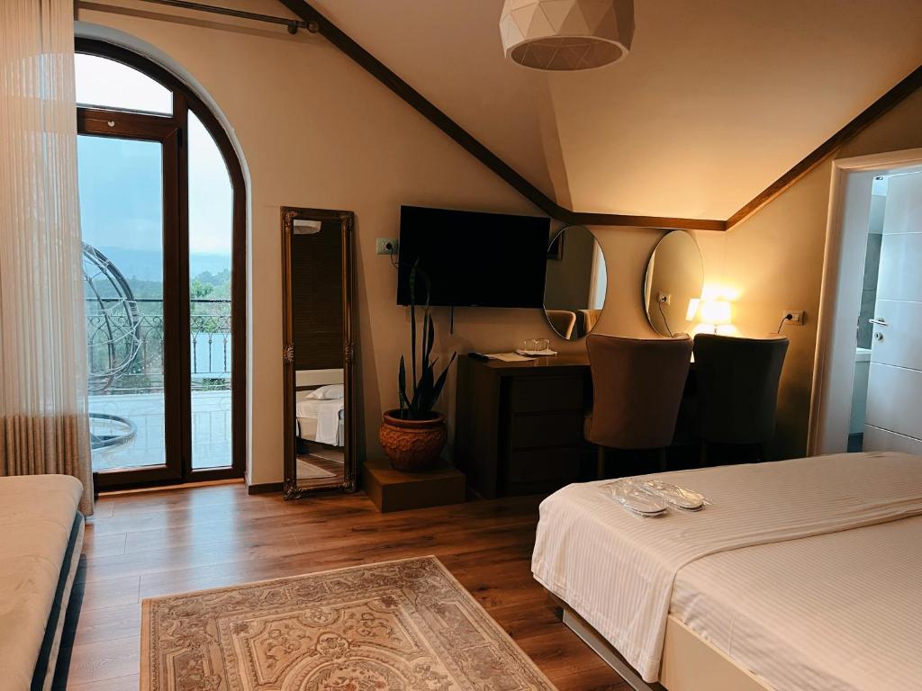 a bedroom with a bed and a desk with a television at Chateau Fasel in Tirana