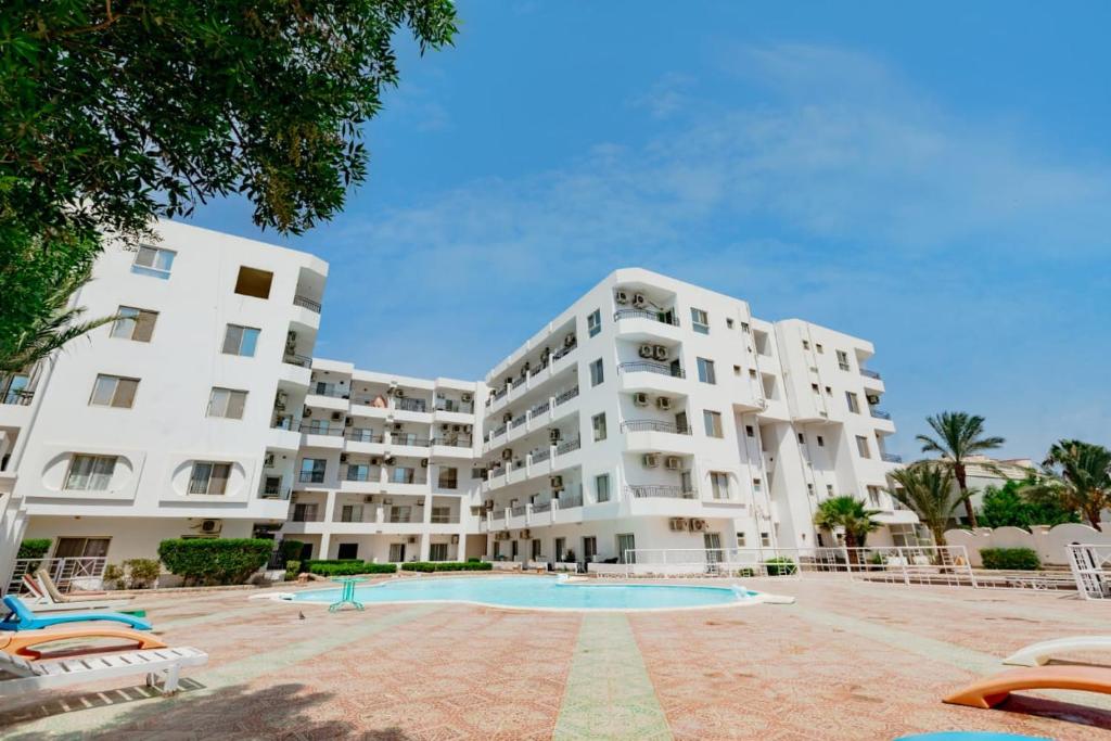 a large white apartment building with a swimming pool at Hurghada Makramia compound in Hurghada