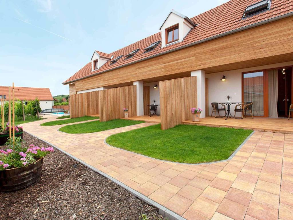 ein Haus mit einer Terrasse und einer Liegewiese in der Unterkunft Rezidence Věstonice in Horní Věstonice