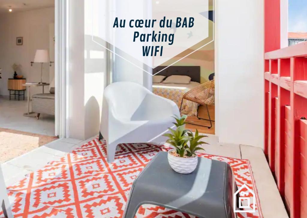 a room with a chair and a table and a bed at Le May'Aïta - Calme, Parking & Central in Anglet
