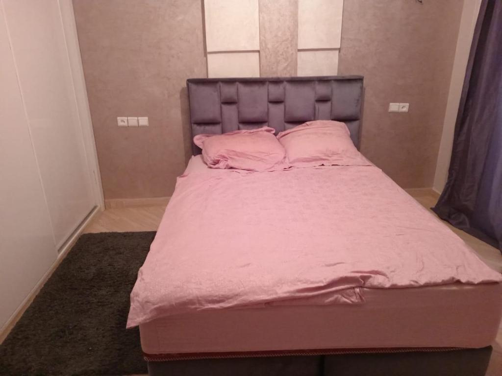 a bed in a room with pink sheets and pillows at Agadir hay wifaq in Agadir