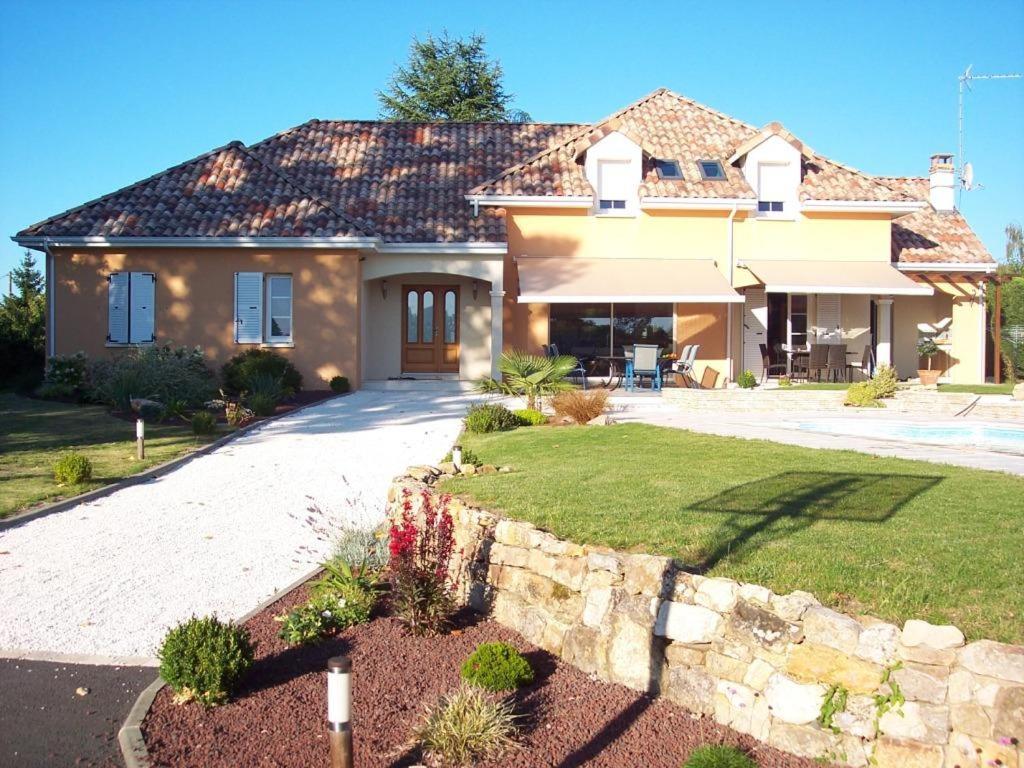 a house with a stone wall and a driveway at Villa du Courboulay in Sargé Les Le Mans 