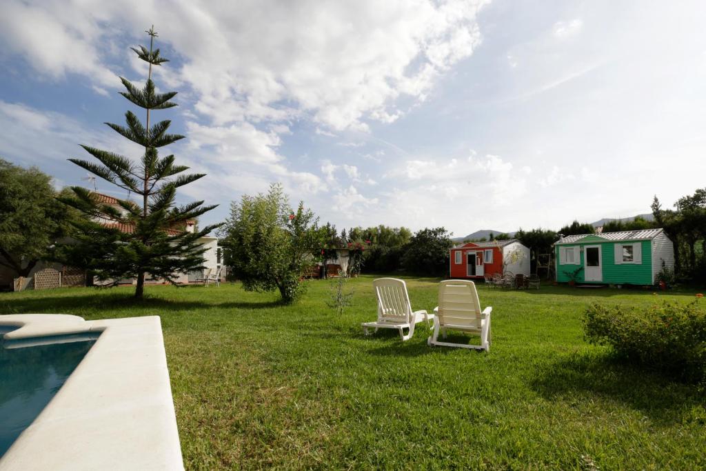 twee stoelen in het gras naast een zwembad bij VILLA MARINA 4 in Los Barrios