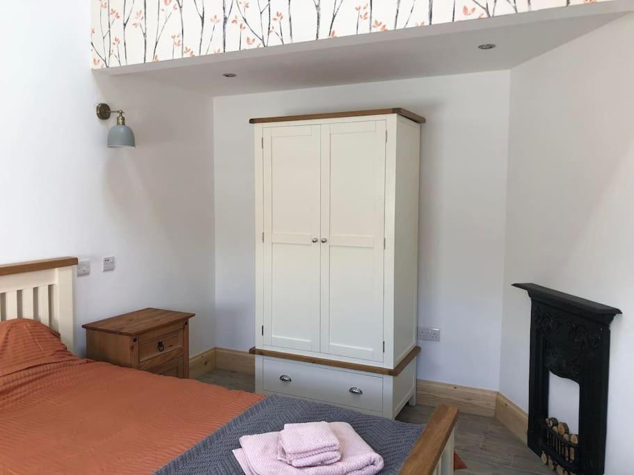 a bedroom with a bed and a white cabinet at Stylish Barn Conversion with Woodland Views in Newark upon Trent