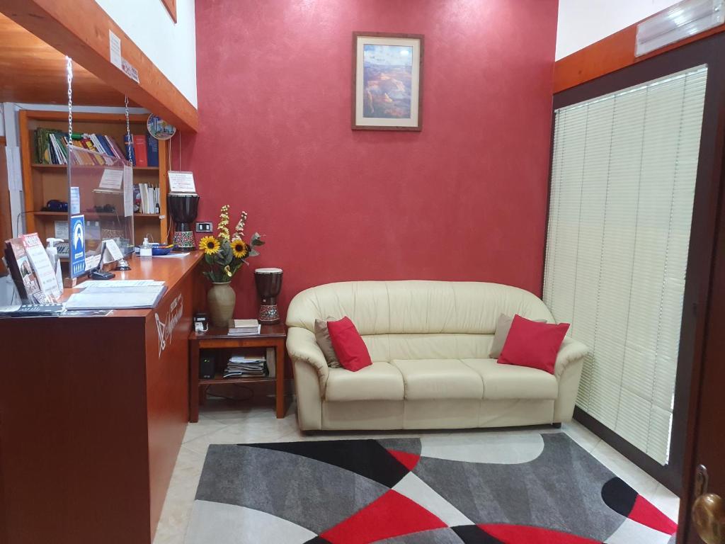 un soggiorno con divano e parete rossa di Hotel Ristorante Supersonik ad Acri
