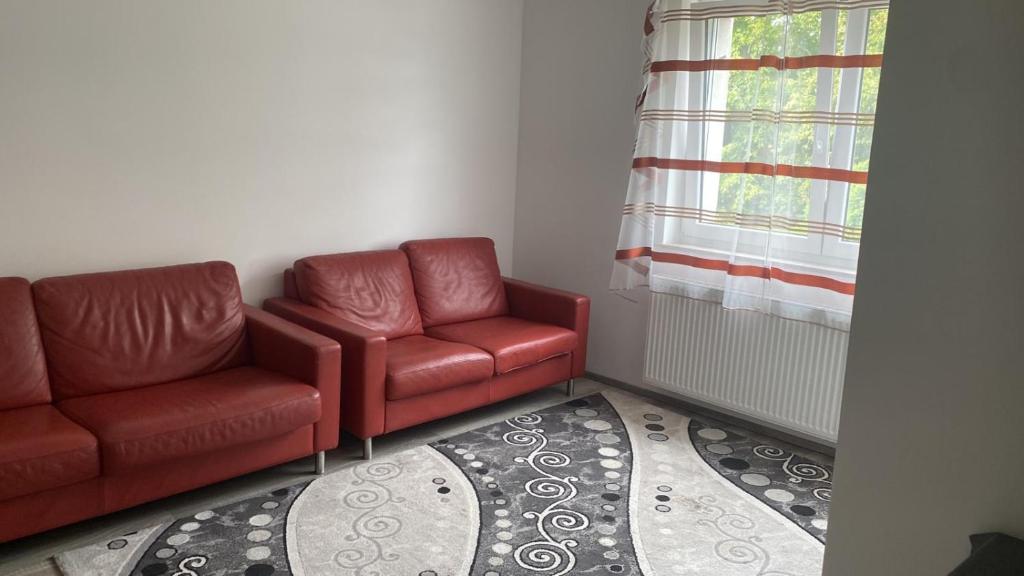 un soggiorno con due sedie rosse e una finestra di NT Dreamhouse a Düren - Eifel