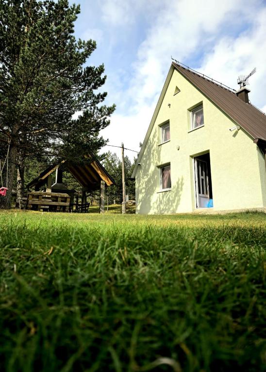 a large white house in a field of grass at Vikendica Mateo in Blidinje