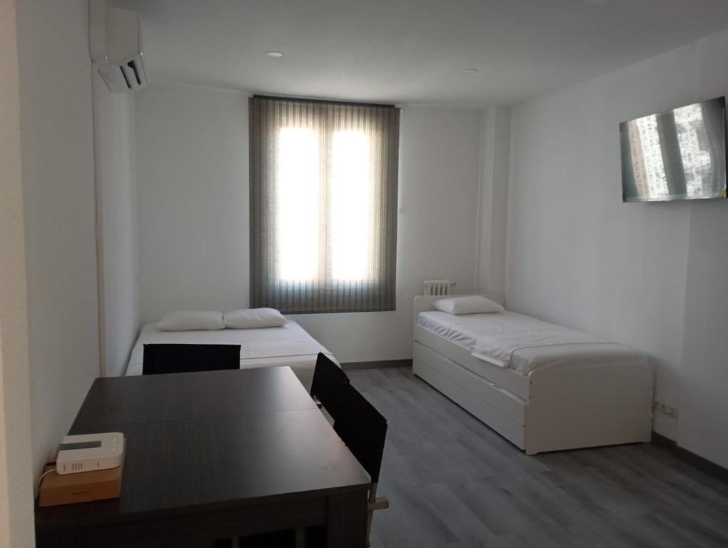 Habitación con 2 camas, mesa y escritorio. en Estudio en Callao, 4 personas, en Madrid