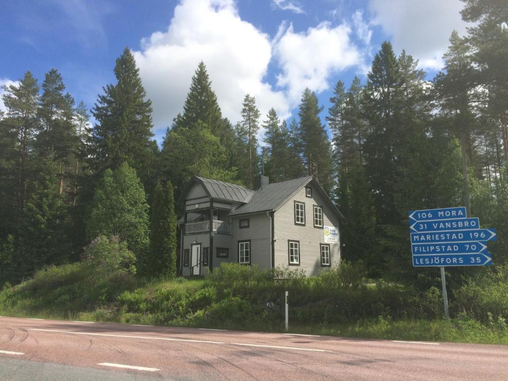 une maison sur le côté d'une route avec un panneau dans l'établissement Route 26, à Laxtjärn