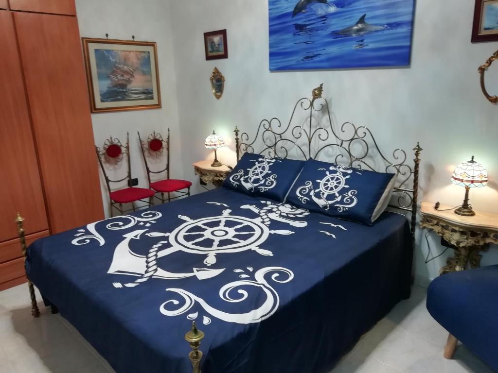 una camera con un letto blu e bianco e due sedie di Sea and Blue Sky 1 a Calimera