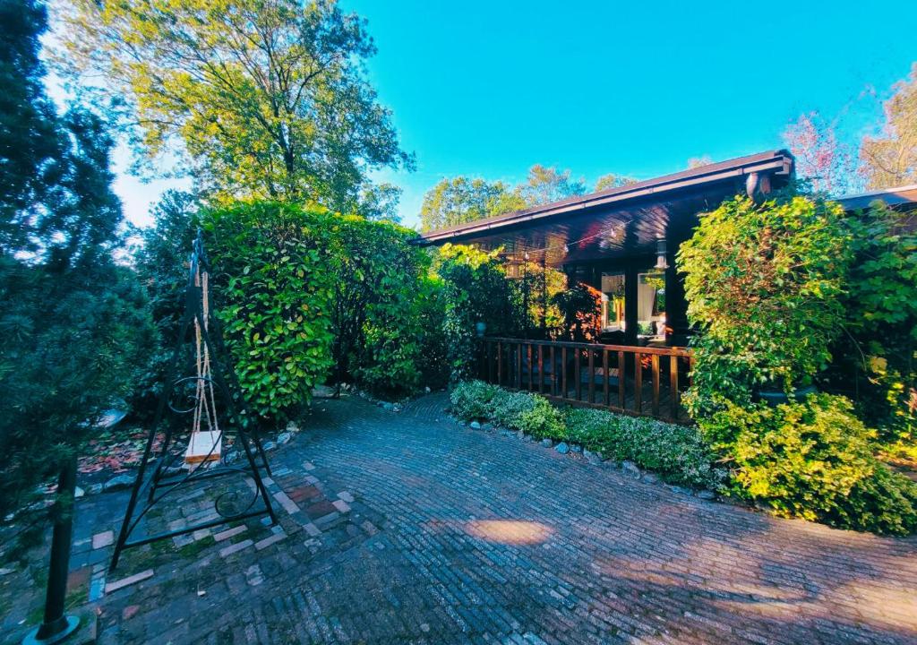 Hattemerbroek的住宿－"De Jungle" Chalet met veranda op IJsselheide Hattemerbroek Veluwe，房屋前的砖砌走道