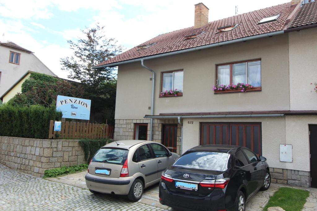 two cars parked in front of a house at Penzion Petra in Telč