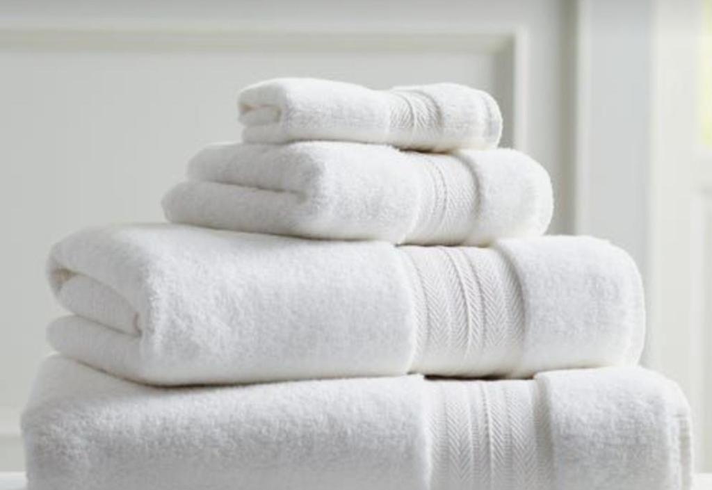 een stapel witte handdoeken bovenop elkaar bij The Executive 5 Bedroom in Manzini