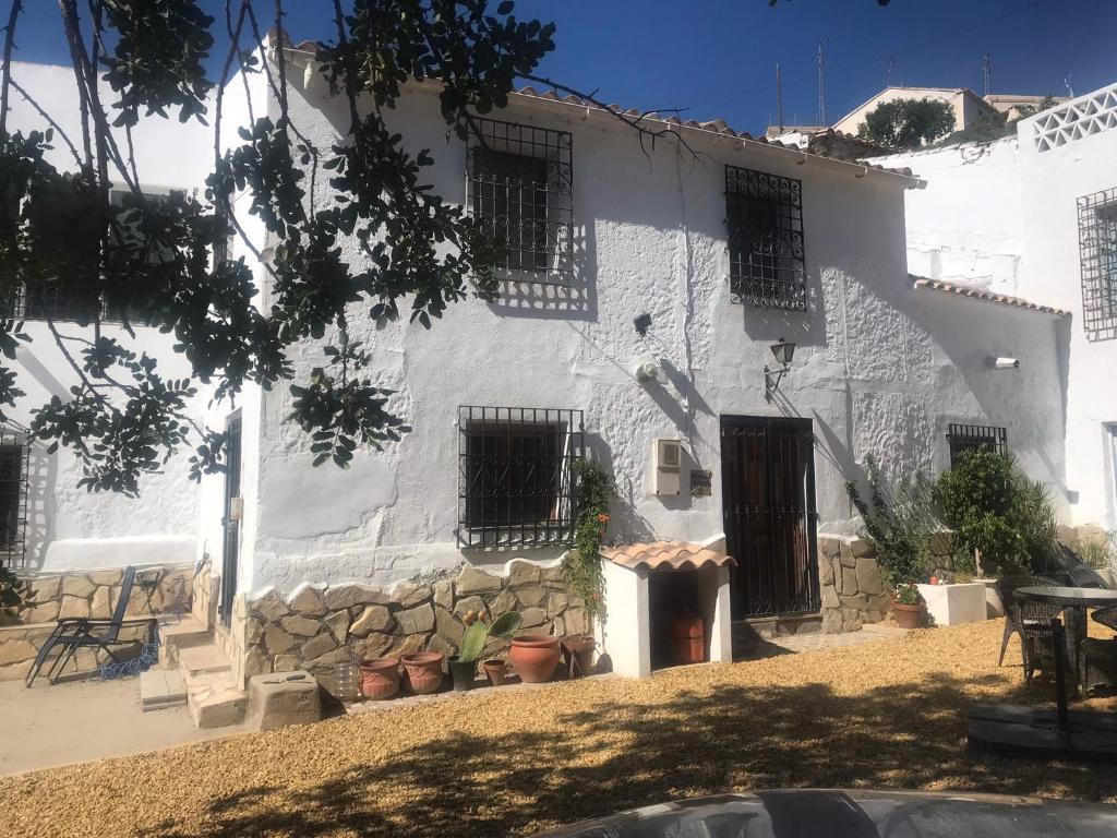 a white building with black barred windows and plants at Casa Tomas in Albox