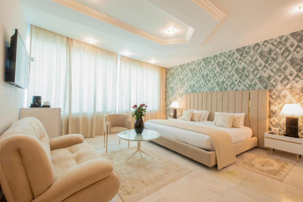 a bedroom with a bed and a couch and a table at The Penthouse Suites Hotel in Tunis