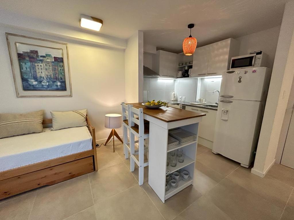 a small kitchen with a bed and a white refrigerator at Apartamento céntrico con garage in Mercedes