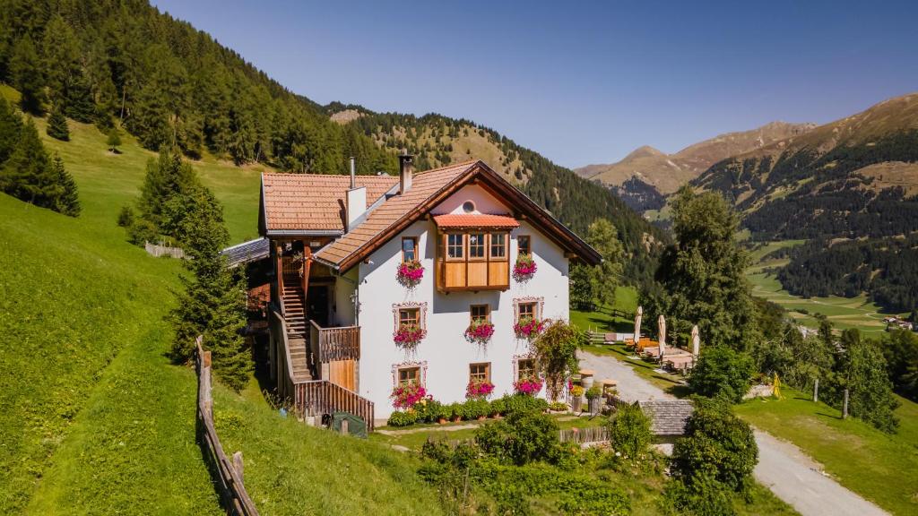 a house on a hill with flowers on it at Tendershof Reschen in Resia
