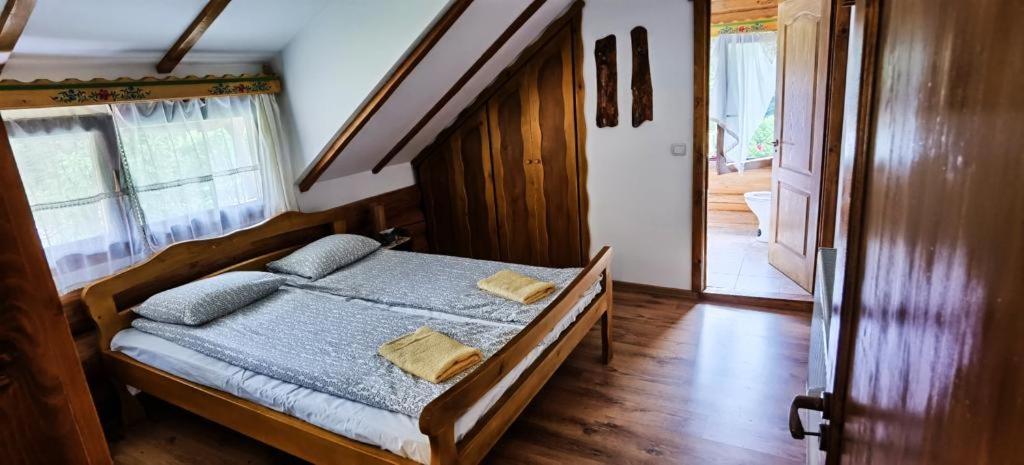 1 dormitorio con cama de madera y almohadas en Casa de sub Sipote en Porumbacu de Sus