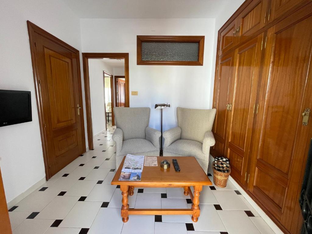 a living room with two chairs and a coffee table at LAS LANZAS in Sabiote